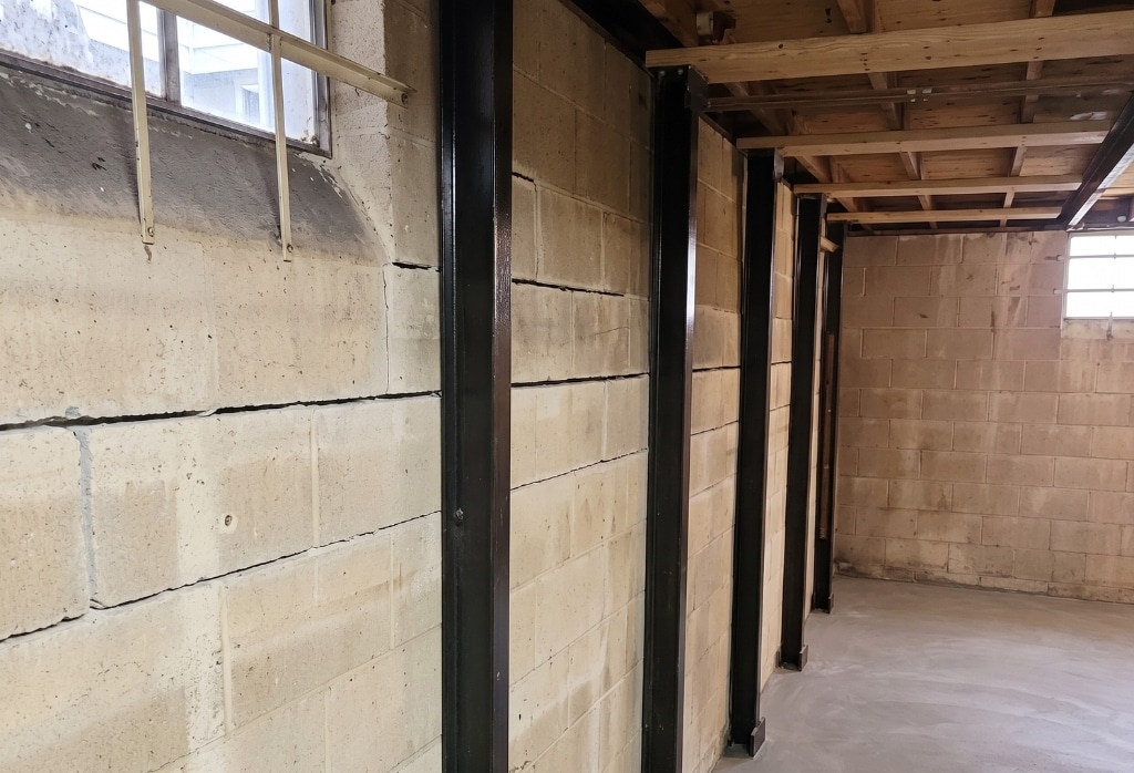 Steel I-beams installed against a foundation wall to brace and stabilize, a bowed foundation wall repair method in Palm Coast, FL.