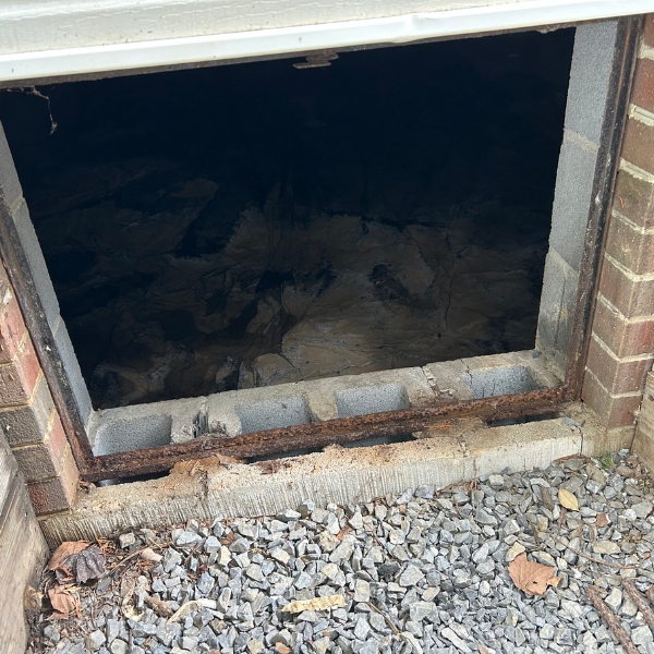 Rusted, damaged access frame caused by a poor or missing crawl space door in St. Augustine, FL, leading to moisture issues.