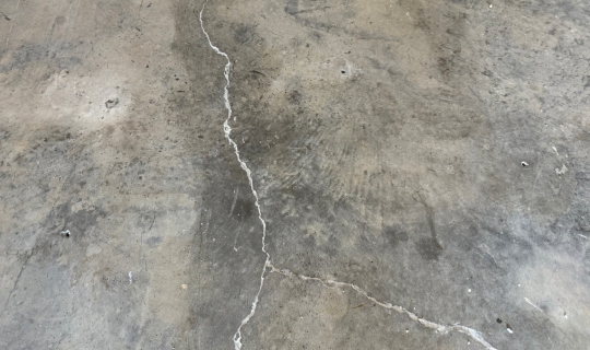 Leveled floor for concrete cracked garage floor lifting in Jacksonville, FL, using polyurethane foam to stabilize uneven slab.