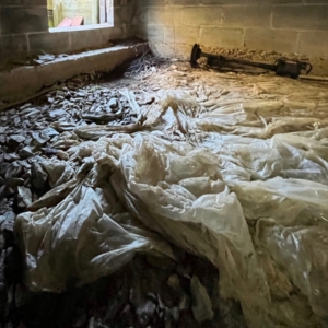 Torn vapor barrier letting ground moisture rise into crawl space, a common cause of wet crawl space issues in Lake City, FL.