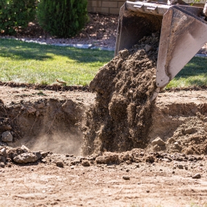 A machine compacting poor soil in the front yard, a cause of foundation settlement in Middleburg, FL.