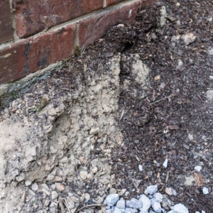 Soil erosion beneath a foundation, leaving voids that cause sinking foundation in Gainesville, FL.