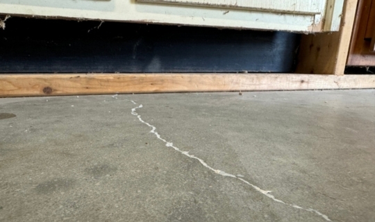 Uneven basement slab lifting in Gainesville, FL, using polyurethane foam to stabilize sunken slab.