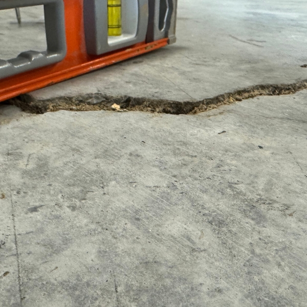 Sloping and cracked concrete floor inside a garage, needing uneven concrete floor repair in Northern Florida.