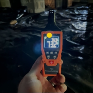 Moisture meter showing high crawl space humidity, revealing how damp air causes an unlevel floor in Palm Coast, FL.