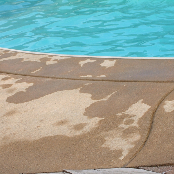 Close-up of cracked pool deck surface caused by soil erosion and moisture intrusion, showing the need for pool deck crack repair in Northern Florida.