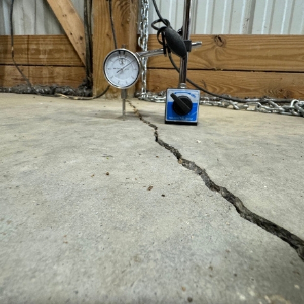 Measuring tool on cracked concrete slab showing uneven surface, needing uneven concrete slab repair in Northern Florida.