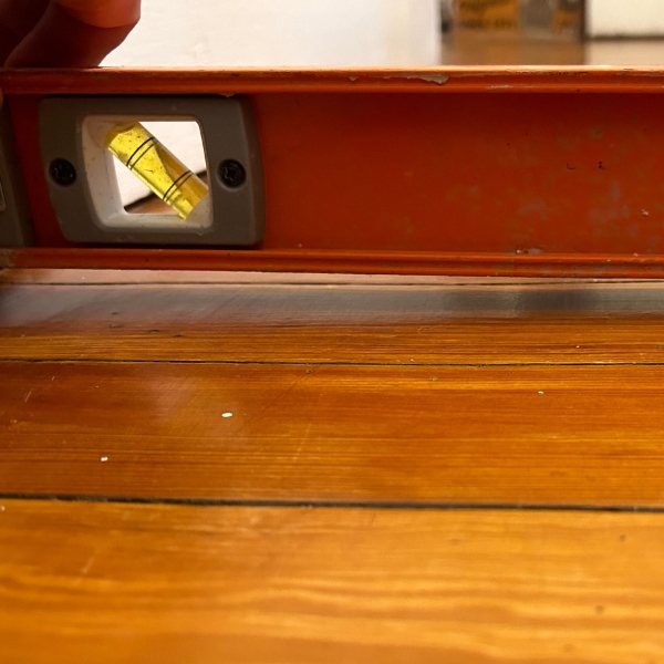 Uneven hardwood flooring showing a slope that indicates crawl space damage and needs unlevel floor repair in Northern Florida.