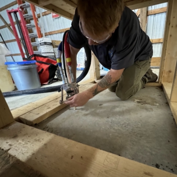 Technician injecting foam to lift a sunken slab after soil loss, a natural disaster foundation damage solution in Fort Lauderdale, FL