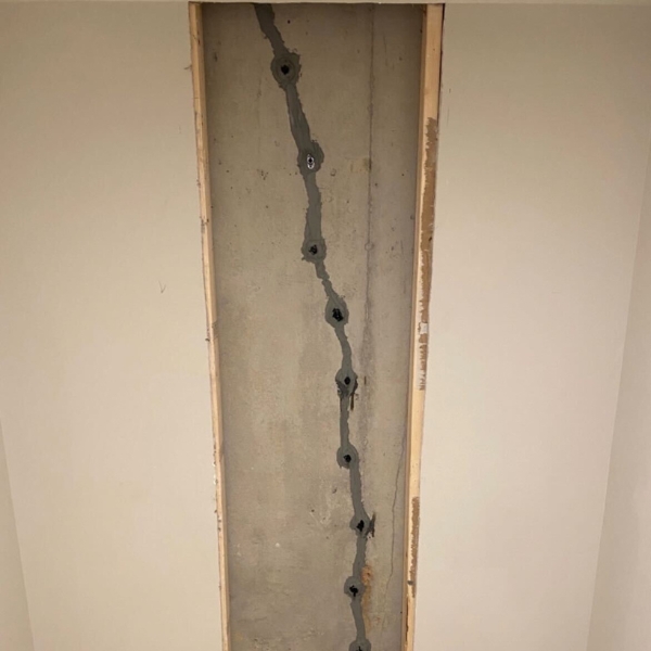 Injected epoxy seals a vertical concrete foundation crack to stop moisture intrusion and reduce basement condensation in Crescent City, FL.