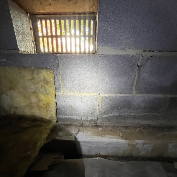 Open crawl space vent allowing humid air to enter beneath a home, needing a crawl space venting solution in Jacksonville, FL.