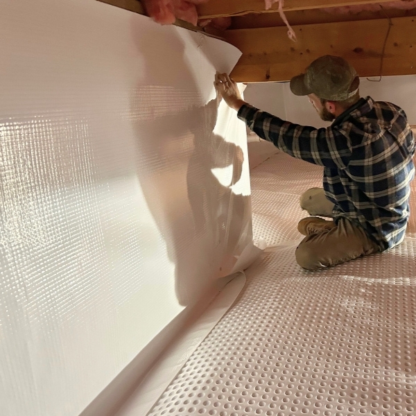 Technician installing a crawl space encapsulation system to control moisture and protect repaired floor joists in Middleburg, FL.