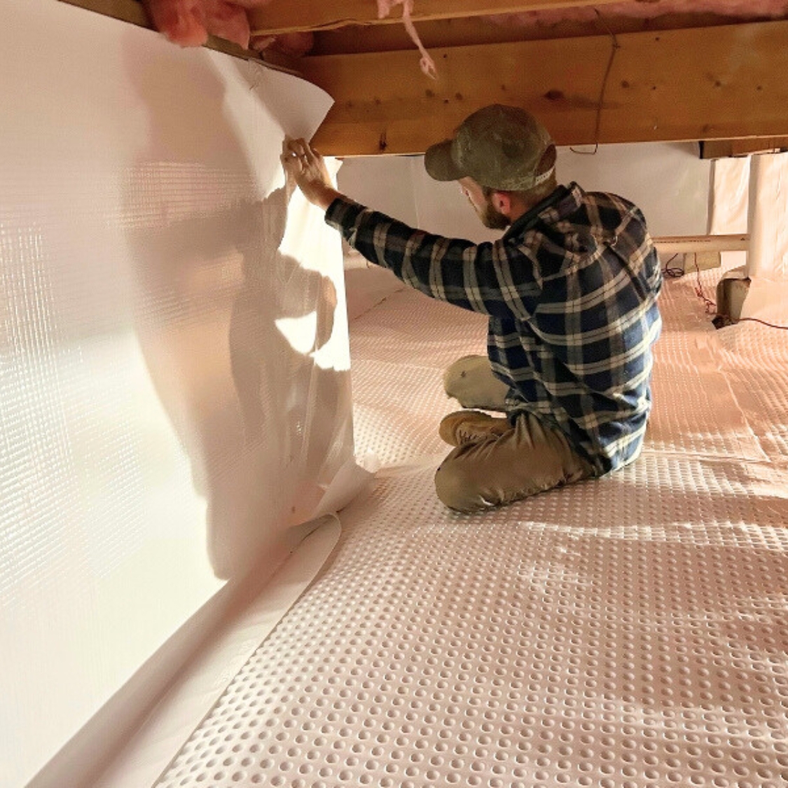 LUX technician installing vapor barrier for expert crawl space repair in Northern Florida.
