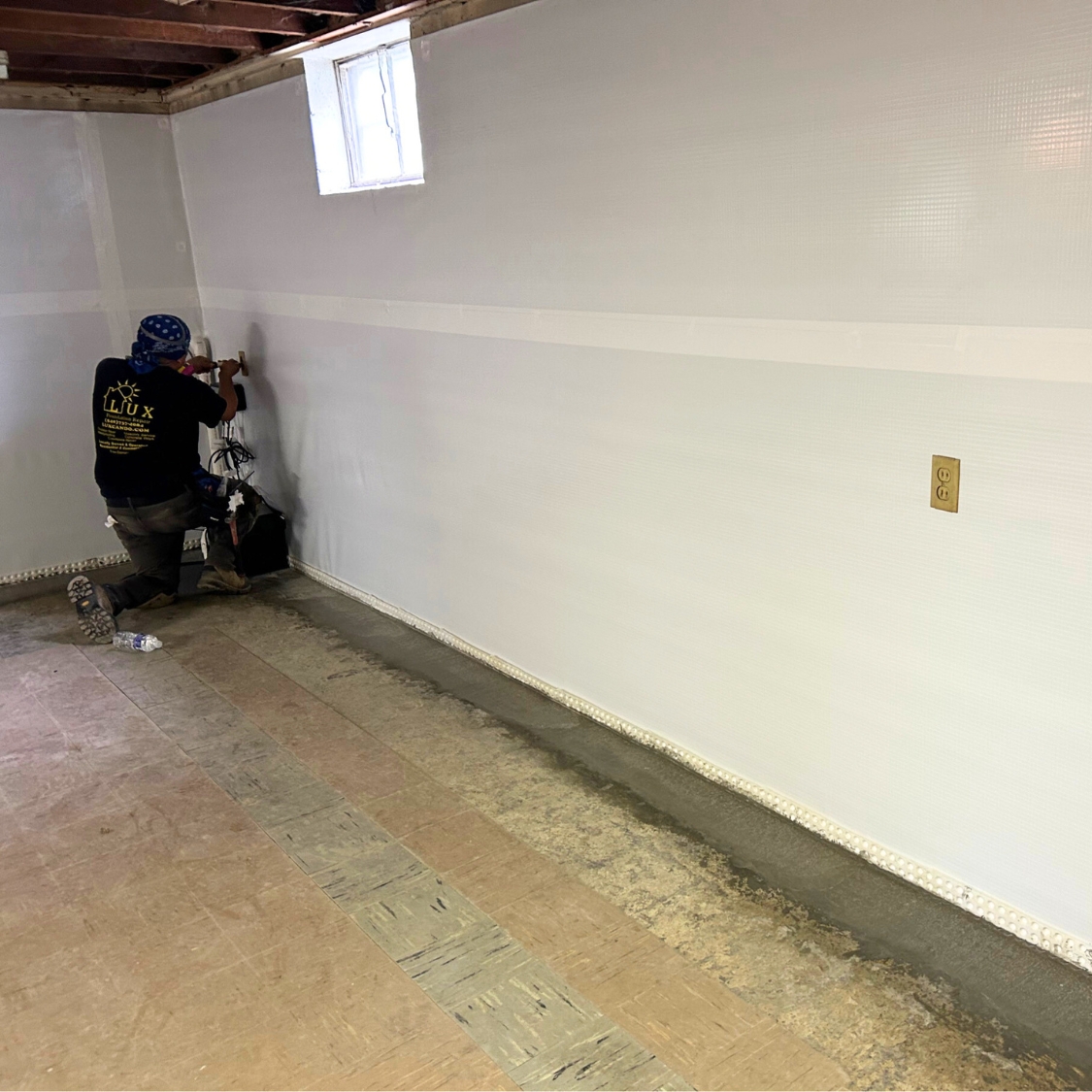 Experts installing a wall vapor barrier to repair water damage, an expert waterproofing solution in Northern Florida.
