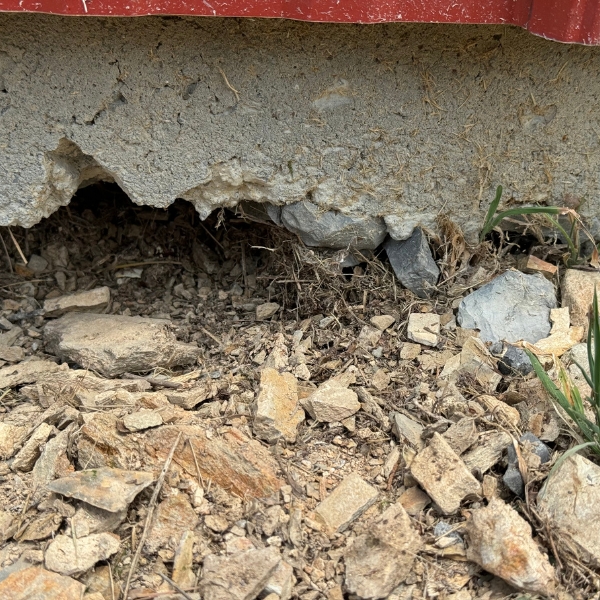 Washed-out soil gaps beneath a home’s foundation, showing uneven settling needing foundation erosion repair in Jacksonville, FL.