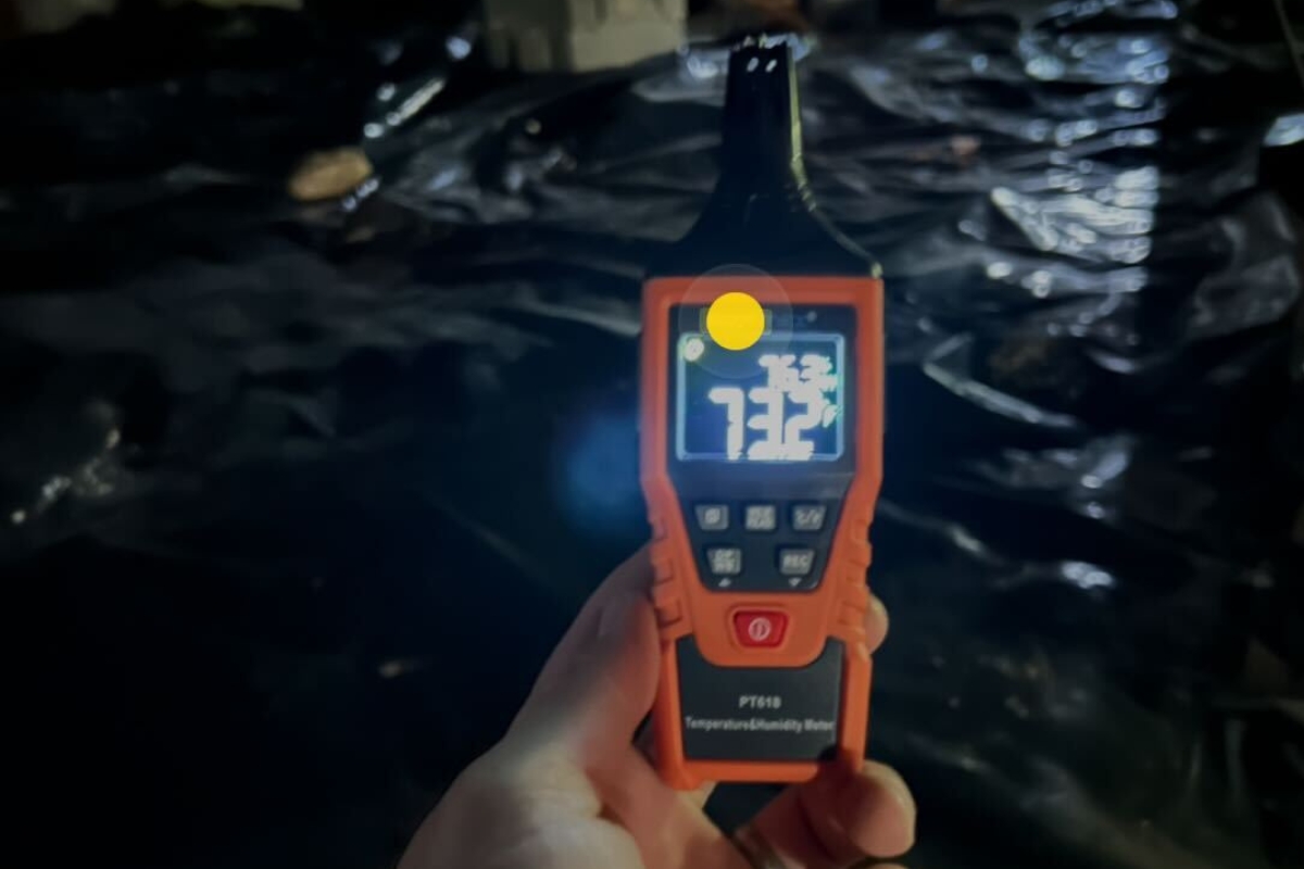 Handheld humidity meter showing high readings, confirming moisture from Florida’s humid air in a vented crawl space in Gainesville, FL.