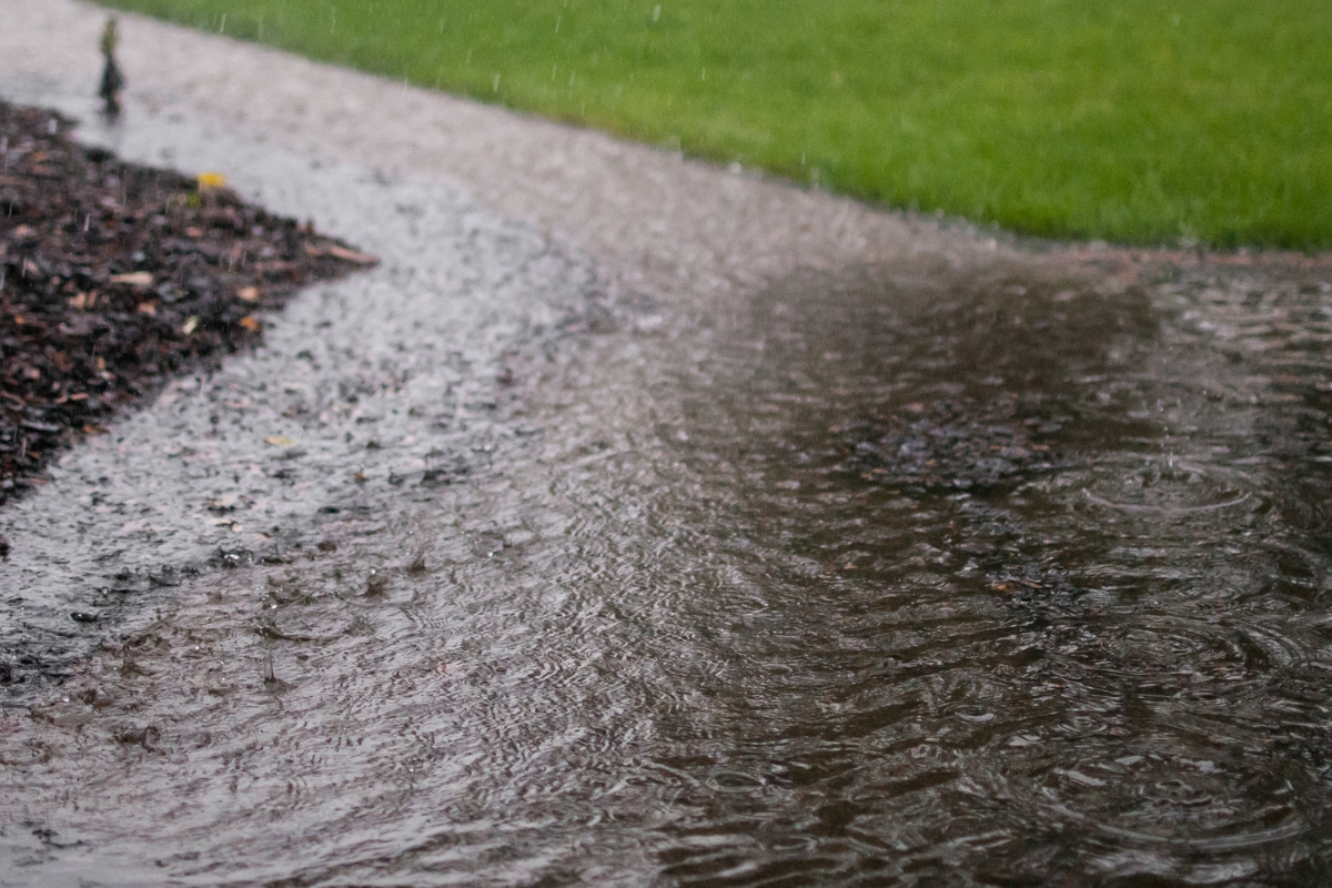 Heavy rain causing a pooled surface, showing how a high water table can send moisture into vented crawl spaces in Ocala, FL.