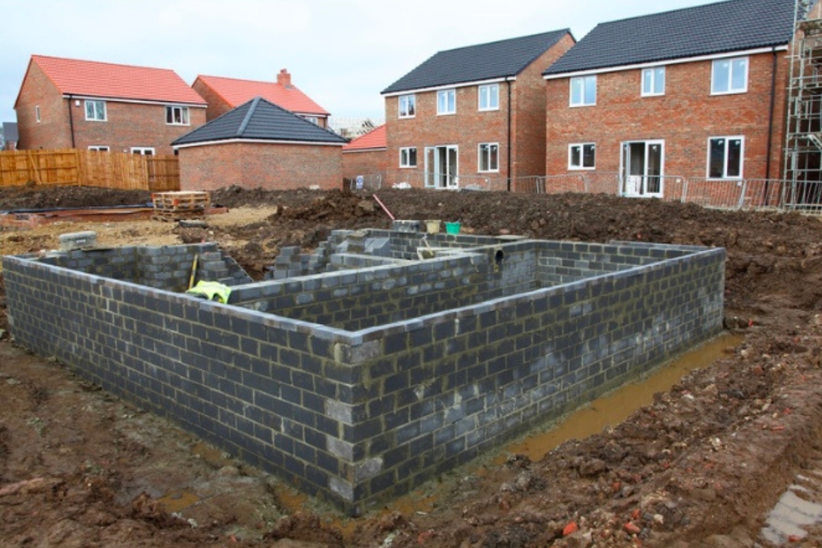 Uncompacted soil surrounding a new foundation showing how poor site preparation causes poor soil compaction in Palm Coast, FL.