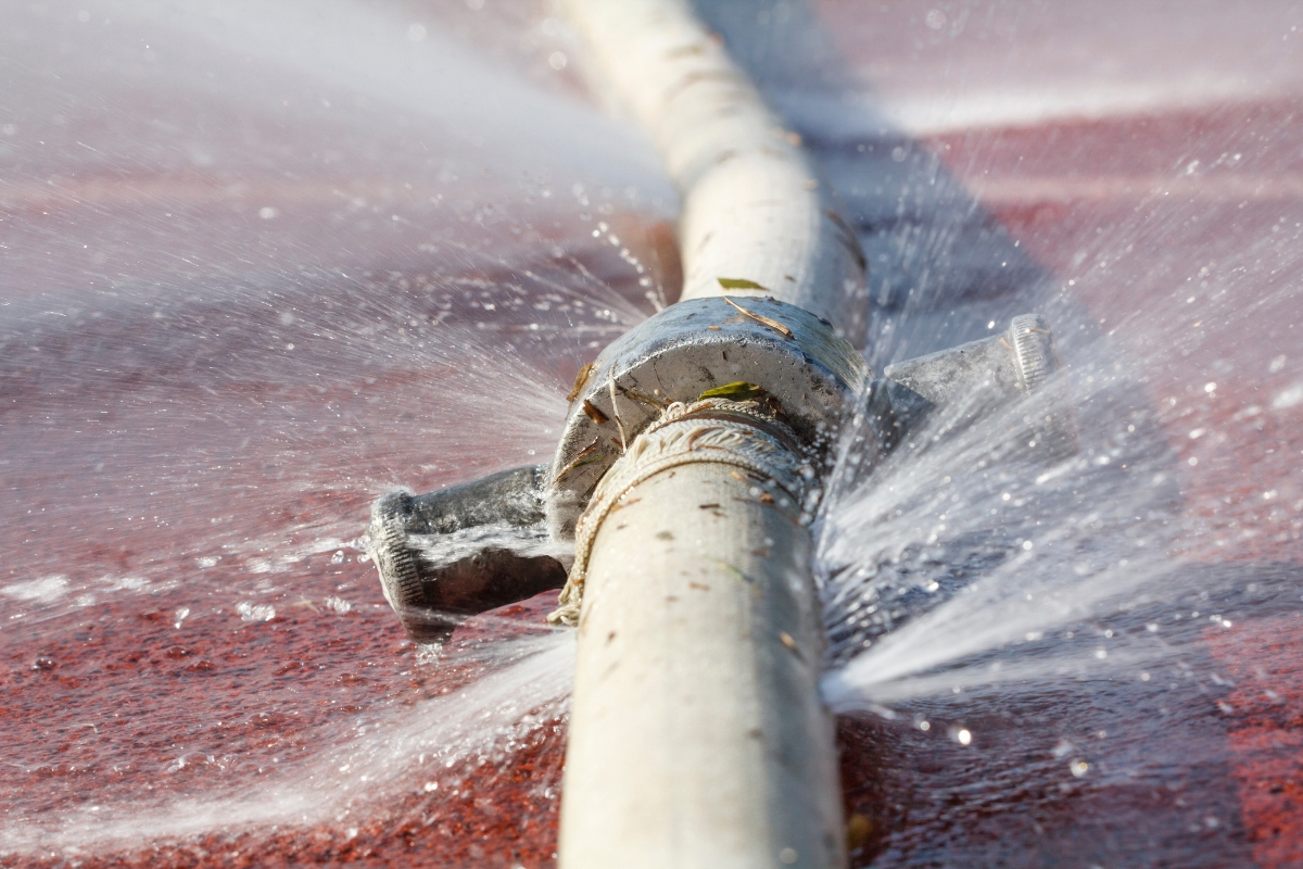 Damaged pipe spraying water, showing plumbing leaks that raise moisture and cause basement condensation in Palm Coast, FL.