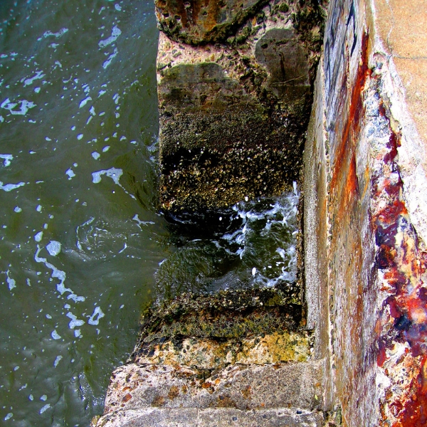 Close-up of corroded rebar inside a concrete seawall, needing seawall rust repair in Northern Florida.