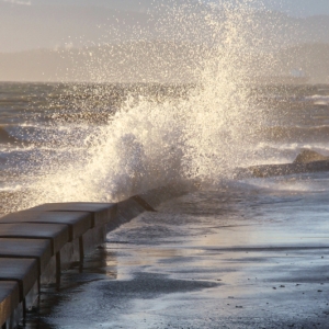 Strong tidal waves eroding soil behind a seawall, causing of tidal seawall washout problem in Palm Coast, FL.