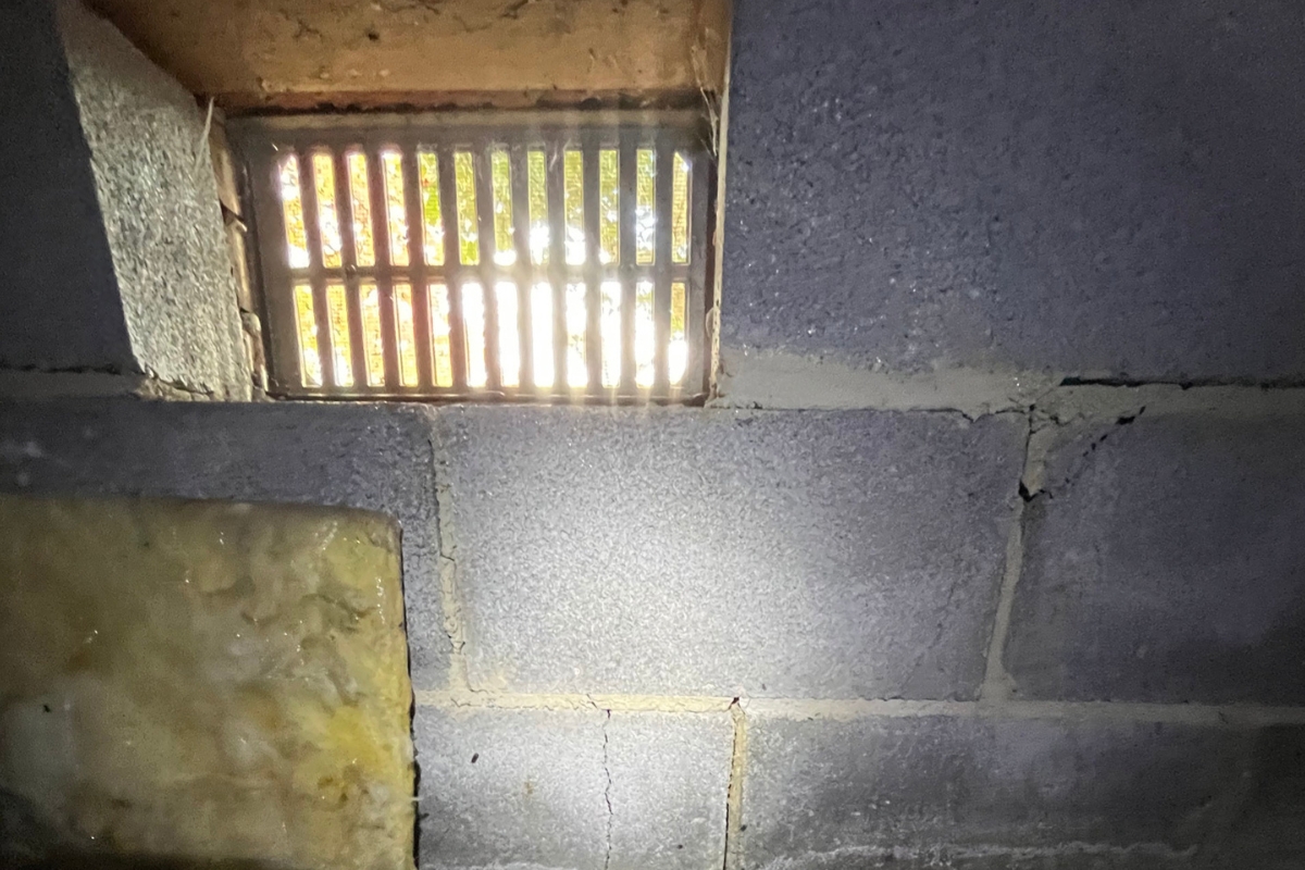 Open crawl space vent allowing outdoor humidity into the area, contributing to moisture problems under a home in Ocala, FL.