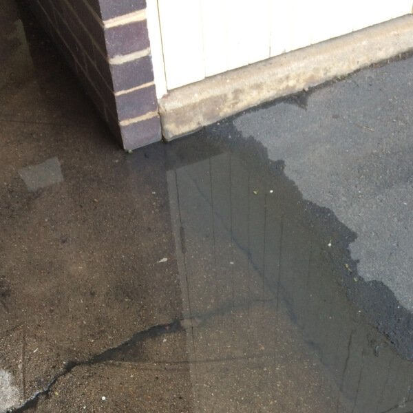 Standing water in a concrete slab, showing early moisture damage that needs concrete water damage repair in Jacksonville, FL.