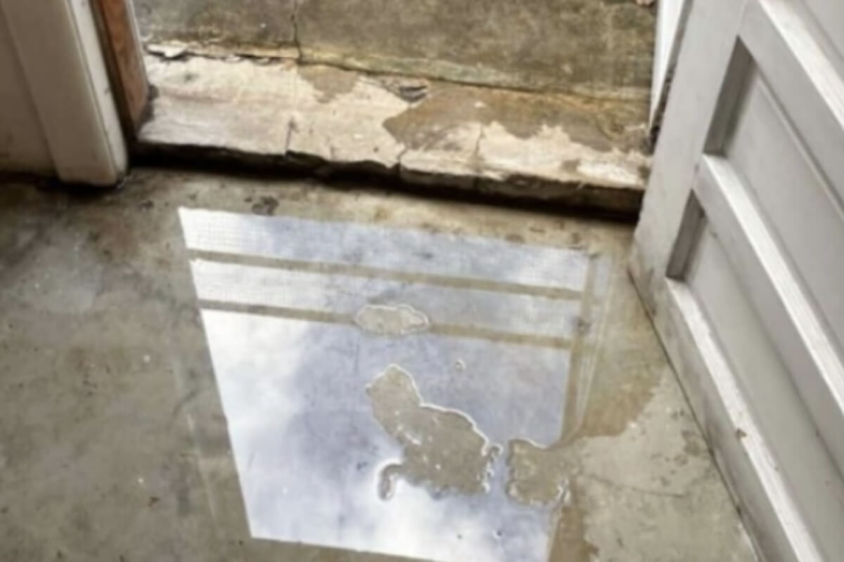 Damp basement floor showing moisture absorption from high humidity, causing concrete water damage in Palm Coast, FL.