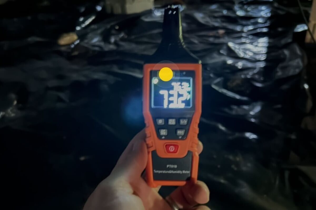 Humidity meter showing high readings inside a dirt crawl space affected by Florida’s humid climate in Palm Coast, FL.
