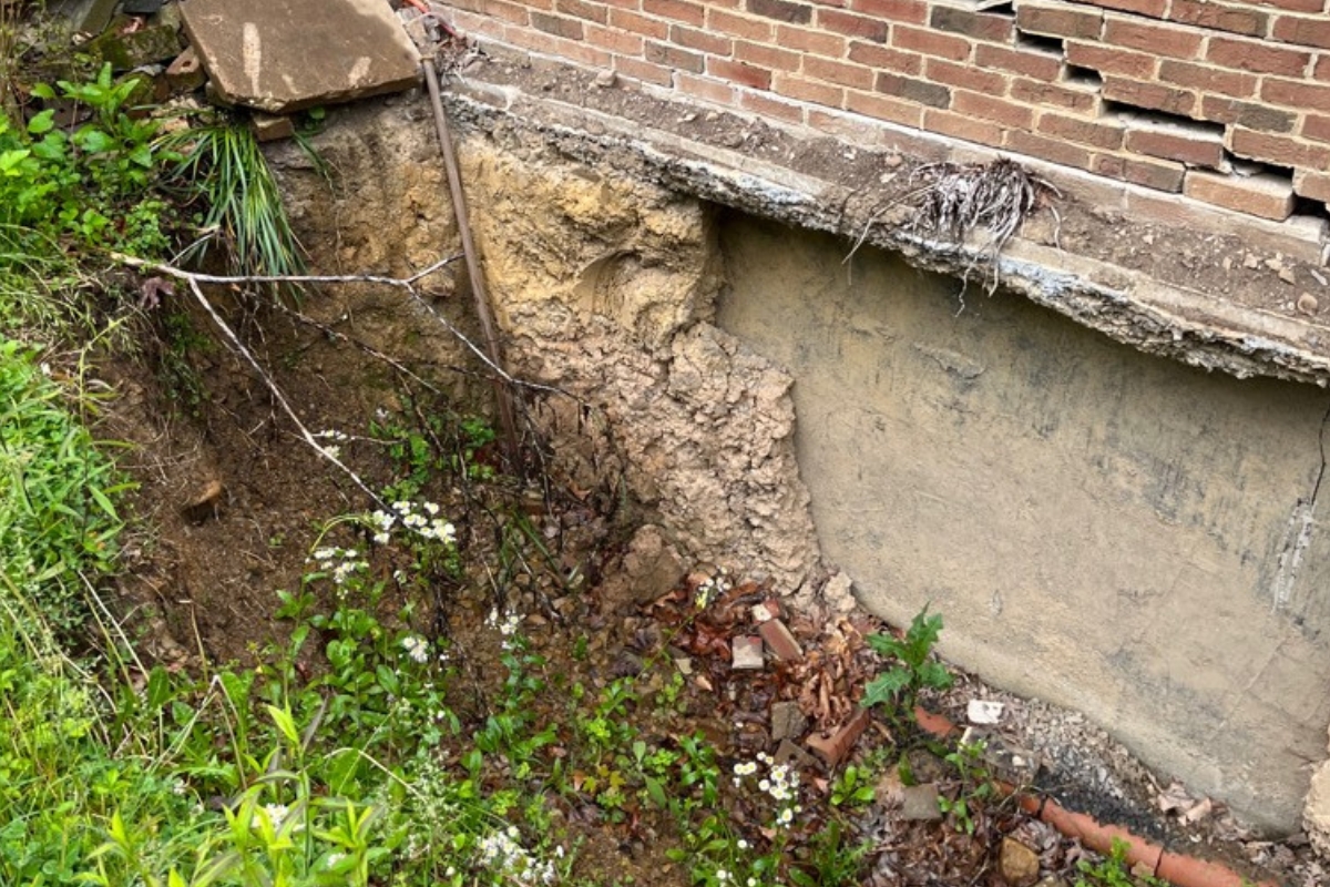 Soil settling away from a home’s foundation, forming low spots due to poor grading, causing crawl space moisture issues in Ocala, FL.