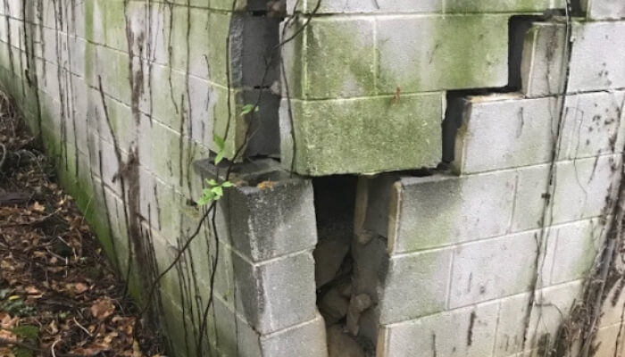 Sinking foundation corner with displaced concrete blocks showing loss of support, a sign of a foundation problem in Jacksonville, FL