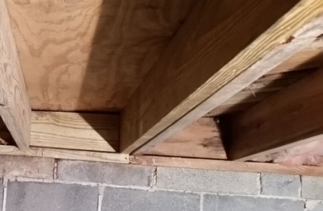Floor joists reinforced inside a crawl space beneath a Palm Coast, FL home to restore structural support.