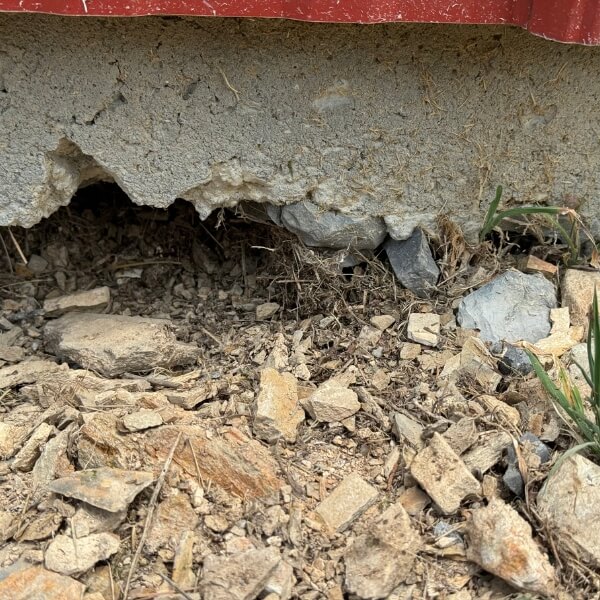 Gaps beneath a concrete slab caused by dried, shrunken soil needing soil-shrinkage concrete repair in Jacksonville, FL.