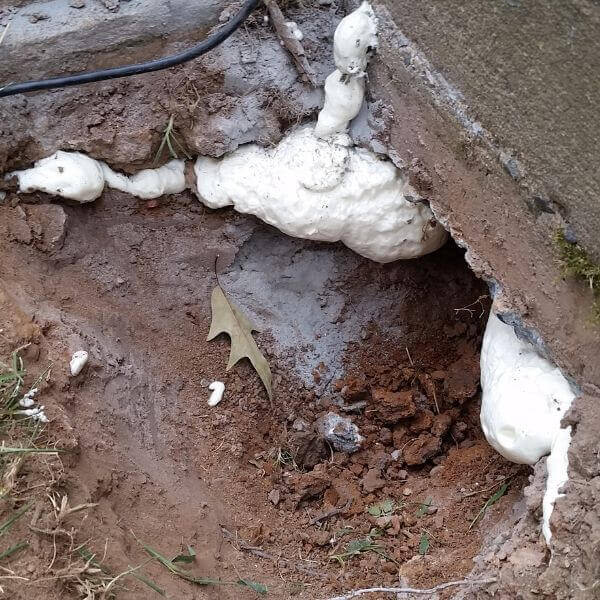 Stabilizing material injected beneath the concrete slab to reinforce soft soil and prevent sinking from heavy loads in Palatka, FL.