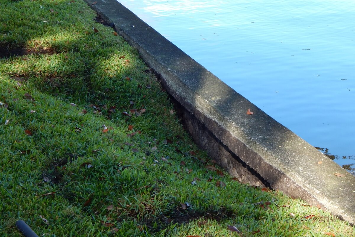 Washed-out soil creating voids behind the seawall after heavy rainfall and flooding, a cause of seawall damage in Palm Coast, FL.