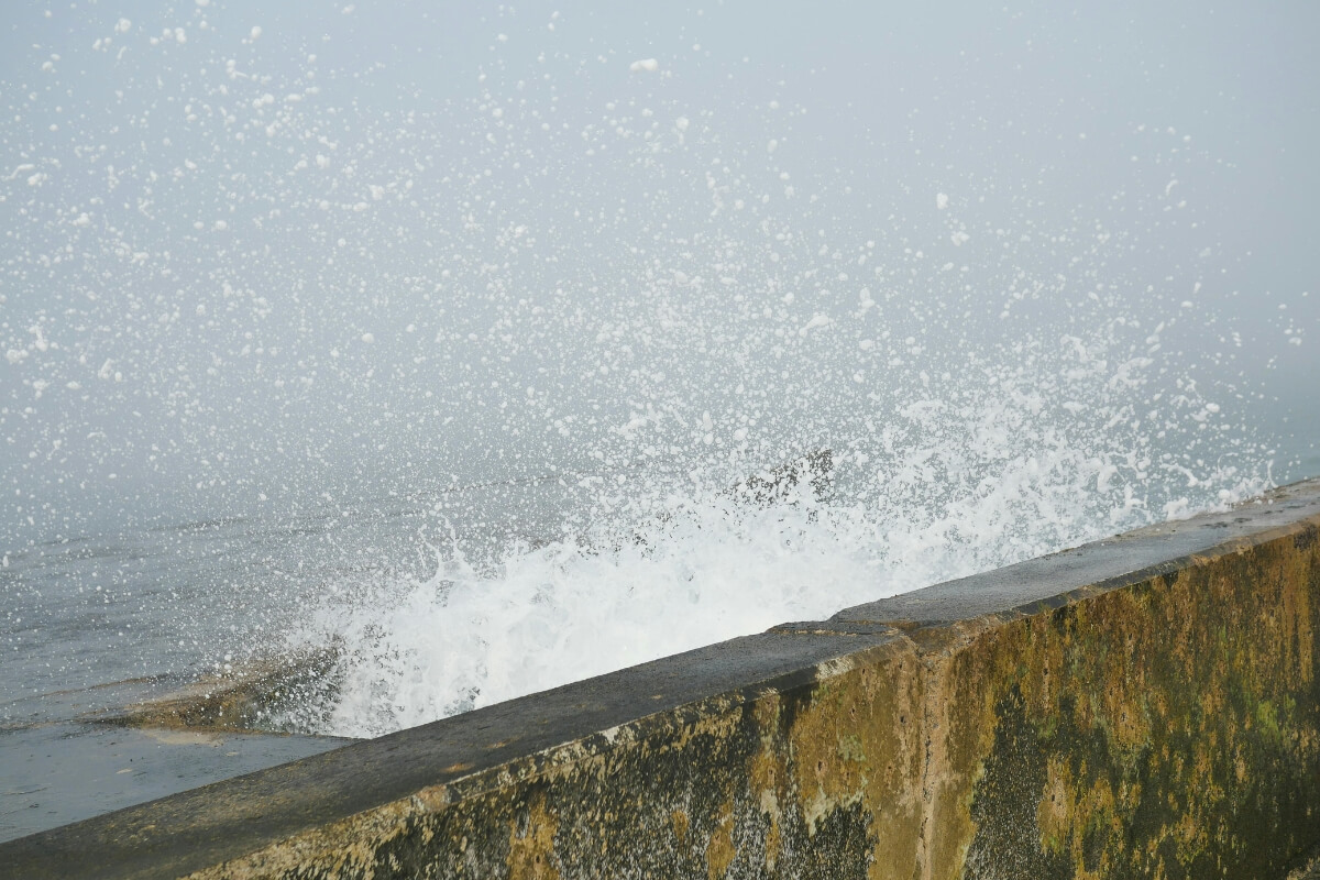 Sea spray and repeated wave impact hitting a concrete seawall cause of seawall general wear & tear in Palm Coast, FL.