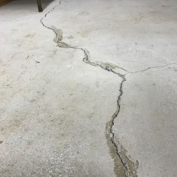 Cracked concrete slab in a home, due to soil movement, settlement, and ground pressure, causing concrete damage in St. Augustine, FL.