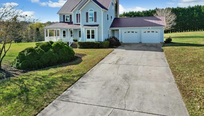 Cracked residential driveway in Ocala, FL showing multiple surface cracks caused by soil movement and moisture exposure near a home.