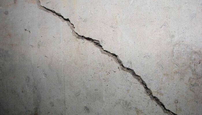 Cracks visible in concrete foundation walls in Ocala, FL, signaling structural movement in the home.
