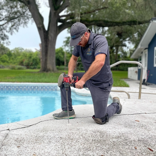 Technician lifting interior concrete slab cracks for expert concrete repair in St. Augustine, Florida home.