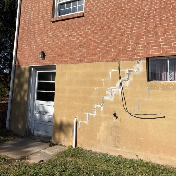 Stair-step cracks visible on an exterior foundation wall, showing structural stress causes foundation damage in Ocala, FL.