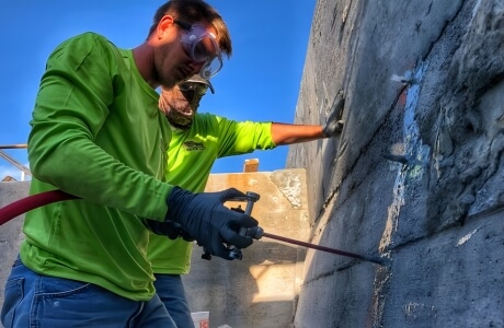 Technicians performing polyurethane grout injection to stabilize the wall for seawall repair solution in Palm Coast, FL.