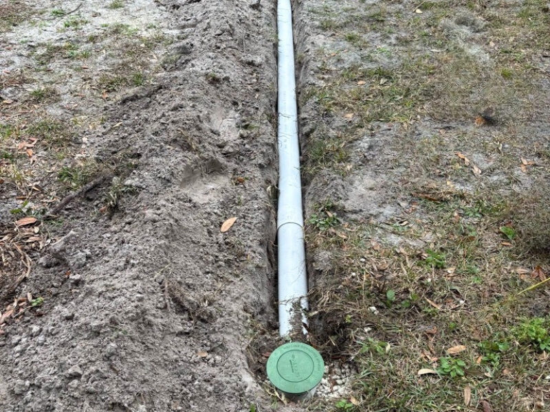 NDS pop-up drainage emitter installed at the end of an underground downspout line in Orange Park, FL, to safely release roof runoff.