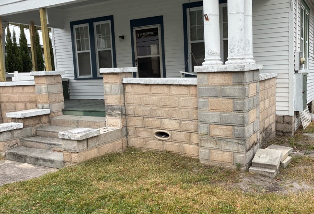 Settling front porch with uneven steps, column base gaps, and shifting masonry before concrete front porch in St. Augustine, FL.