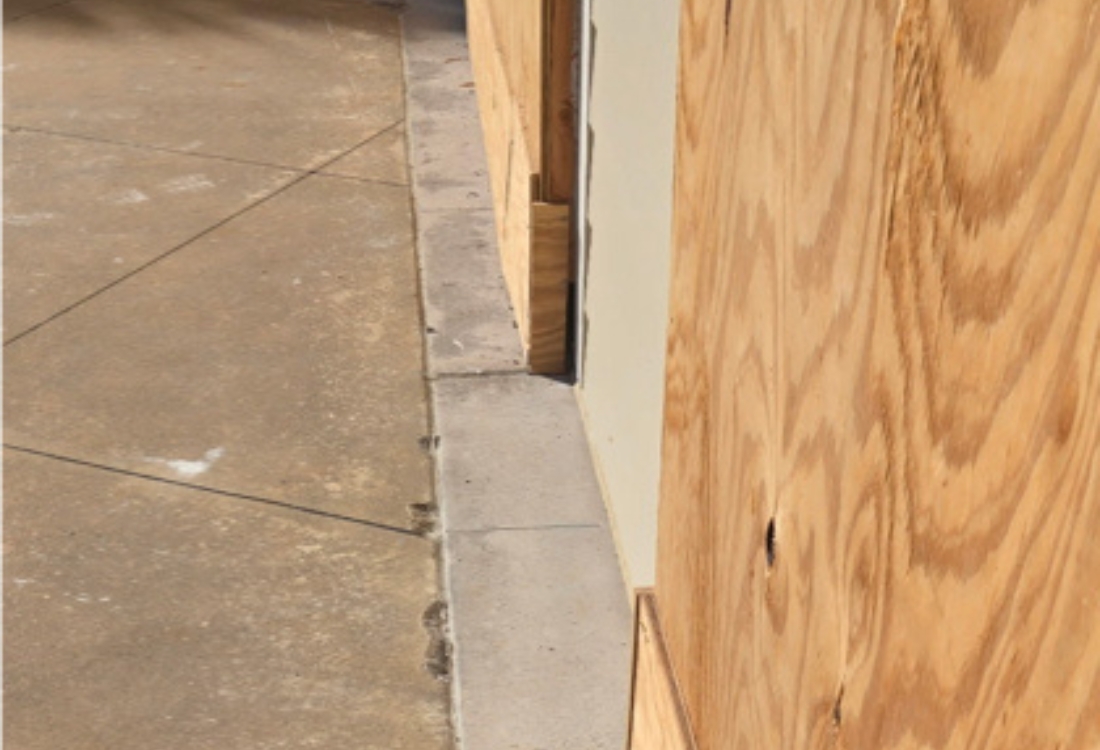 Patio slab surface deterioration and perimeter vulnerability before exterior waterproofing restoration in Fernandina Beach, FL.