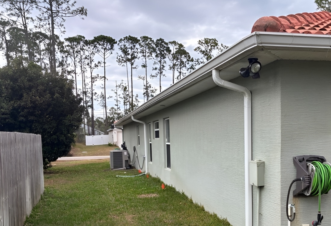 Exterior stucco wall showing vertical cracks from active foundation settlement before push pier installation in Palm Coast, FL.