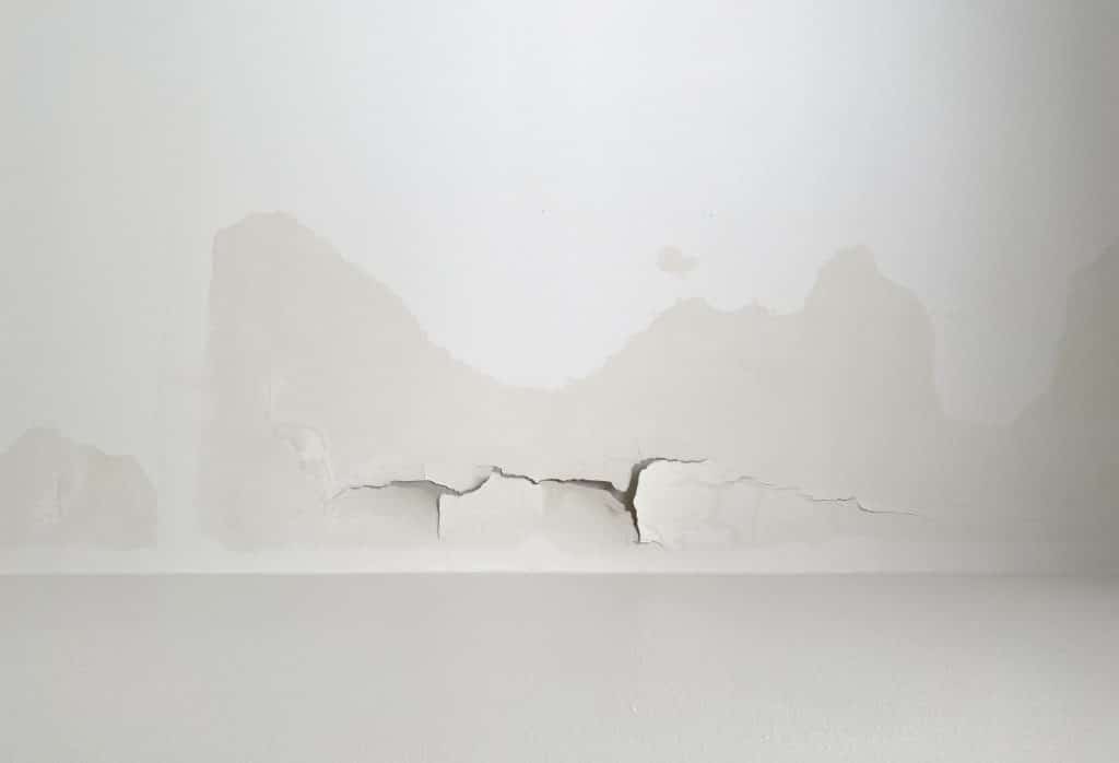 Horizontal ceiling crack with paint bubbling and moisture staining in a Florida home caused by water intrusion from above.