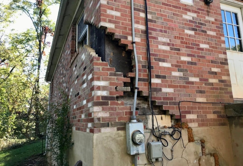 Stair-step brick cracking and wall collapse showing foundation damage caused by expansive soil movement in Ocala, FL.