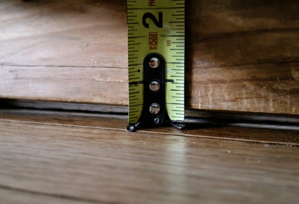 Tape measure showing a 2-inch gap between floor and wall, indicating foundation movement due to expansive soil in St Augustine, FL.