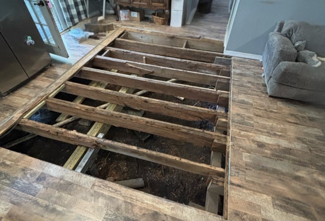 Removed sub-floor exposing damaged floor framing and joists before crawl space support post repair in Callahan, FL.
